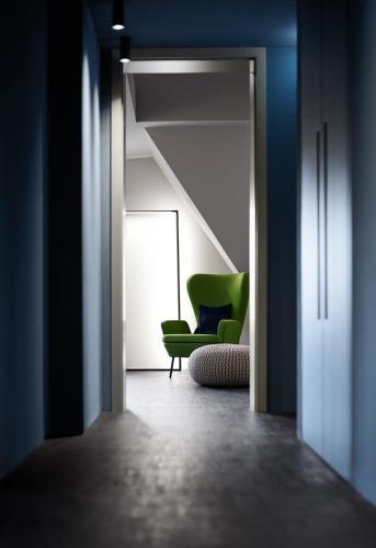 a living room with a green chair and a window at Mittermeiers Alter Ego in Rothenburg ob der Tauber