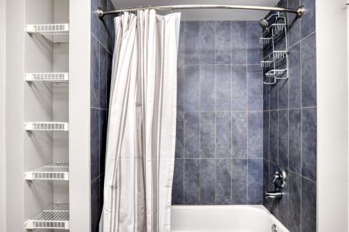 a bathroom with a shower with a white shower curtain at Loop 1br w pool gym lounge nr Riverwalk CHI-634 in Chicago