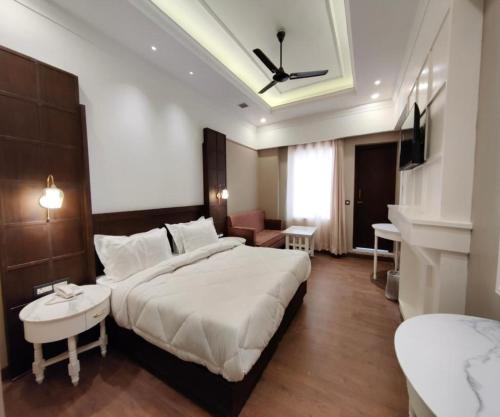 een slaapkamer met een groot bed en een woonkamer bij Hotel ND Manor in Dehradun