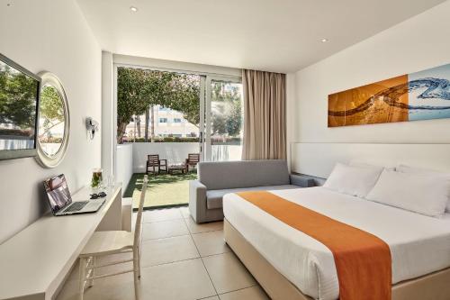 a hotel room with a bed and a desk at Atlantica Sancta Napa Hotel in Ayia Napa