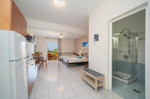 eine Küche und ein Wohnzimmer mit einem Kühlschrank und einem Tisch in der Unterkunft Agnanti Studios in Lourdata