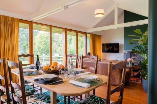 a dining room with a wooden table and chairs at Le Manoir du Lys, The Originals Relais in Bagnoles de l'Orne