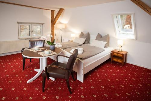 a bedroom with a bed and a table and chairs at Jägerhaus Donaueschingen in Donaueschingen