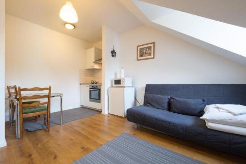 uma sala de estar com um sofá azul e uma mesa em Mainhatten Apartment em Frankfurt