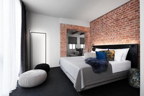 a bedroom with a bed and a brick wall at Mittermeiers Alter Ego in Rothenburg ob der Tauber