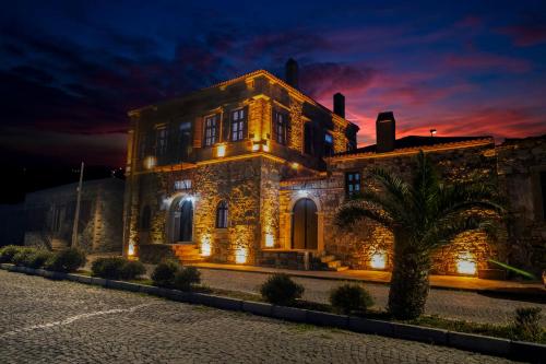 un gran edificio de piedra con luces encendidas por la noche en Kocanli Kosku, en Dikili