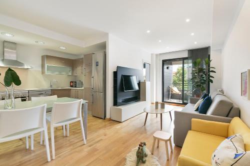 uma sala de estar e cozinha com um sofá e uma mesa em Sardenya Apartment by Olala Homes em Barcelona