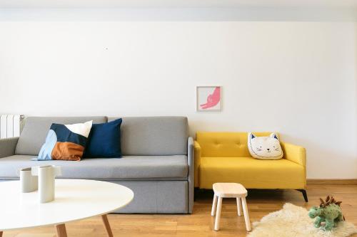 uma sala de estar com um sofá e uma cadeira amarela em Sardenya Apartment by Olala Homes em Barcelona