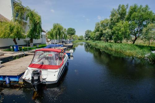 a boat is docked at a dock on a river at WPO - WILD PIKE OASIS in Caraorman