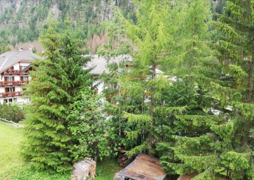 a group of trees in front of a building at Cèsa Pier Sellaronda Dolomiti in Campitello di Fassa