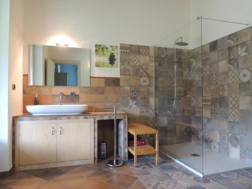 uma casa de banho com um lavatório e uma cabina de duche em vidro. em B&B CASA BELLA COMBA em Vignolo
