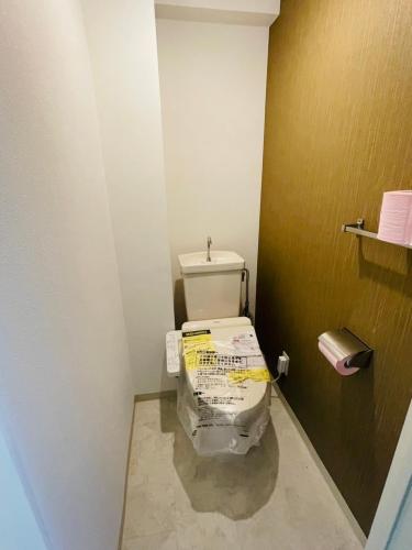 a bathroom with a toilet wrapped in plastic at ASUKA HINODECHO ｌ日の出町 in Kusugaurachō