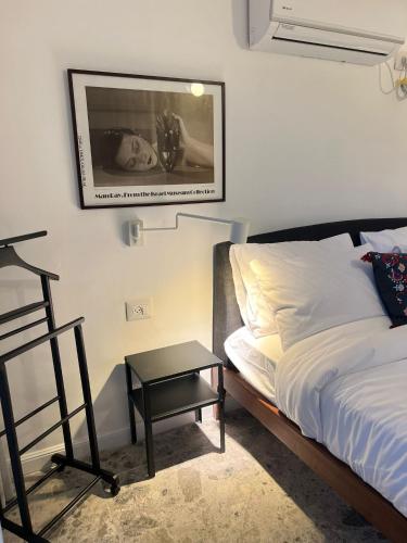 a bedroom with a bed and a chair and a picture on the wall at דירת גן על הים בנהריה in Nahariyya