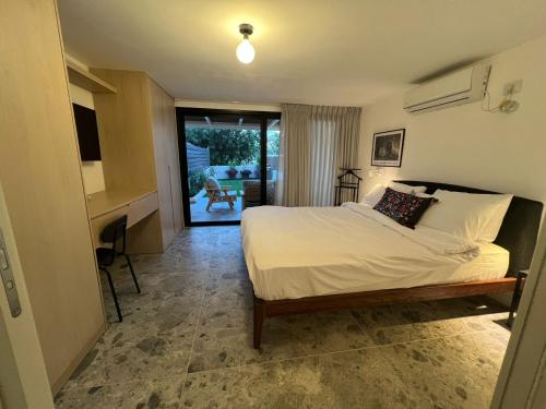 sypialnia z łóżkiem i biurkiem w obiekcie דירת גן על הים בנהריה w mieście Naharijja