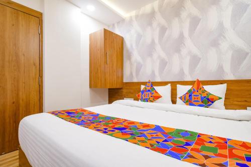 1 dormitorio con 2 camas y una manta colorida en FabHotel Woodlark Inn en Indore