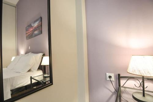 a mirror in a room with a bed and a lamp at Central Apartment in Xylokastron