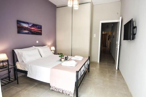 a bedroom with a large white bed and a television at Central Apartment in Xylokastron