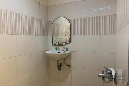 W łazience znajduje się umywalka i lustro. w obiekcie OYO 92775 Wisma Phinisi Syariah 