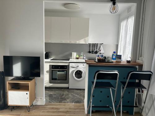 a kitchen with a stove and a sink and a dishwasher at Cosy studio proche la Défense in La Garenne-Colombes