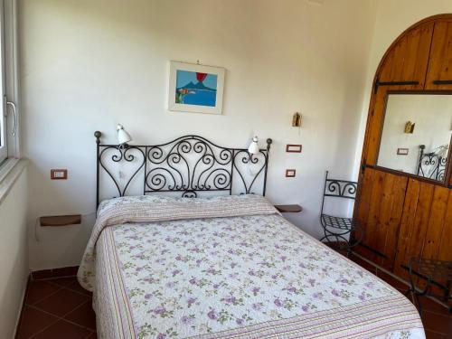 a bedroom with a bed with a floral bedspread at la Dacia di Gina in Ravello