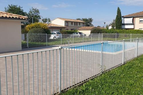 a fence around a swimming pool in a yard at Appartement jacuzzi mondonville in Mondonville