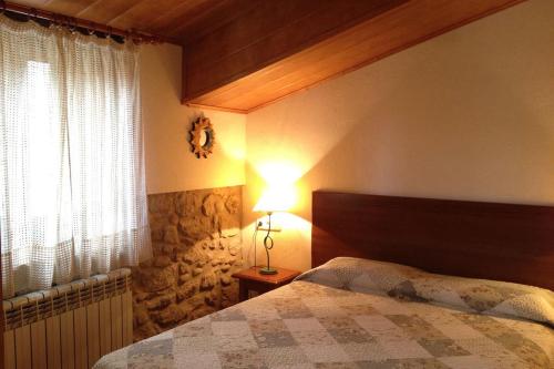 una camera con letto, lampada e finestra di Pla 3 a Lladurs