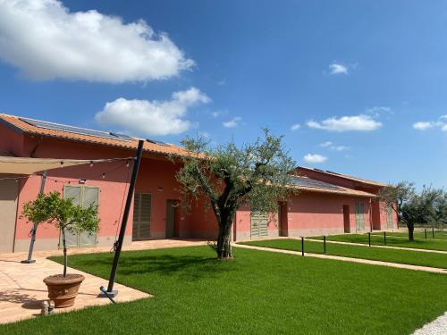 un bâtiment avec un arbre en face d'une cour dans l'établissement Borgo Sant'Anna, à Bettona