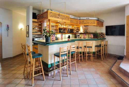 a bar in a restaurant with stools at Hotel Landhaus Zell am See in Zell am See