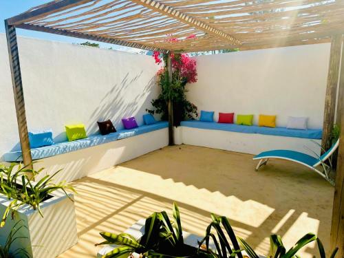 a pergola with colorful cushions on a patio at Takasira Appart Hotel centre ville in Fort Dauphin