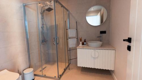 een badkamer met een douche, een wastafel en een spiegel bij Mehmet Bey Çaka By Trippters in Perşembe
