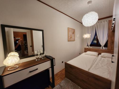 a bedroom with a bed and a dresser with a mirror at Apartments & wellness Kal Koritnica in Bovec