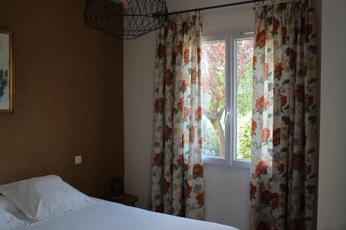 a bedroom with a bed and a window with curtains at Bastide Saint Bernard in Le Thoronet