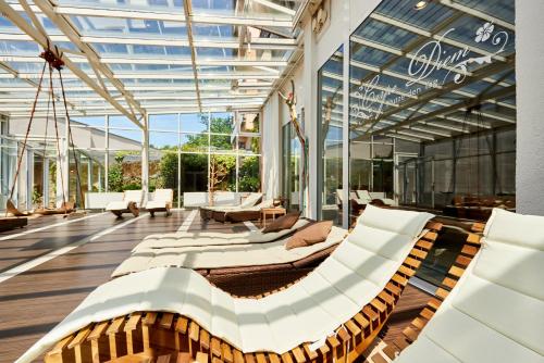 a conservatory with white furniture and a glass ceiling at Hotelpark der Westerwald Treff in Oberlahr