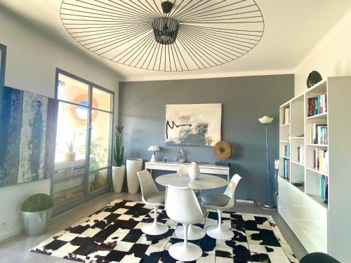 une salle à manger avec une table, des chaises et un lustre dans l'établissement Oasis à Marseille 8e vue exceptionnelle, à Marseille