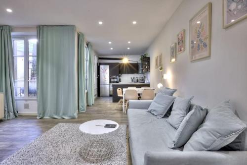 Il comprend un salon avec un canapé gris et une cuisine. dans l'établissement La Maison Hélène & Antoine Nice Le Port, à Nice