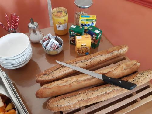 a table with bread and a knife and other ingredients at Les tilleuls in Épernay-sous-Gevrey