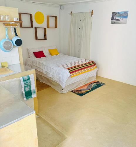a bedroom with a bed in the corner of a room at Takasira Appart Hotel centre ville in Fort Dauphin