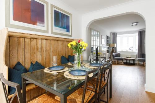 a dining room with a glass table and chairs at Wonderful Seafront Home - Panoramic Ocean Views in Selsey