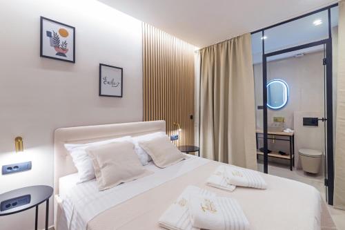 1 Schlafzimmer mit einem weißen Bett und einem Badezimmer in der Unterkunft Tonio Rooms in Zadar