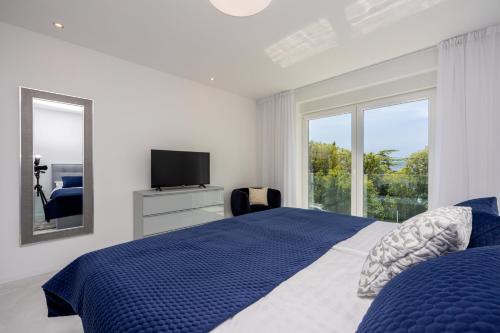 um quarto com uma cama, uma televisão e uma janela em Amarie 2 em Dramalj