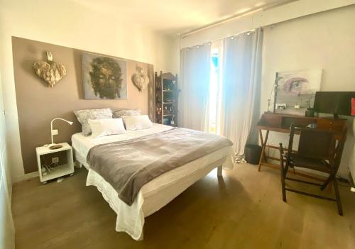 een slaapkamer met een bed, een bureau en een raam bij Oasis à Marseille 8e vue exceptionnelle in Marseille