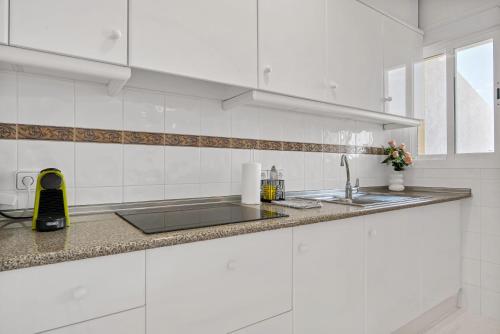 una cucina bianca con lavandino e bancone di Clementina Imperial Park a Casas de Torrat