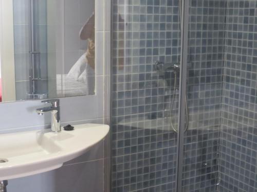 y baño con lavabo y ducha acristalada. en Apartamentos Turísticos El Losal, en Úbeda