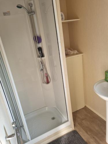 a shower stall in a bathroom next to a sink at Skipsea sands holidays in Ulrome