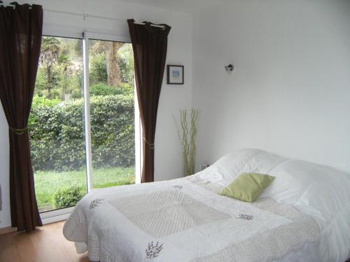 a bedroom with a bed and a large window at La Palibe in Tarnos