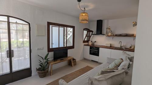 a living room with a couch and a tv at Hostal Es Niu de Tamariu in Tamariu