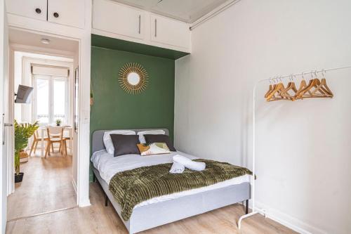 ein Schlafzimmer mit einem Bett und einer grünen Wand in der Unterkunft Le Zola - charmant 2 chambres - centre gare in Reims
