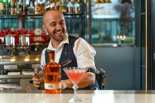 a man sitting at a bar with a drink at Radisson Blu Hotel Bucharest in Bucharest