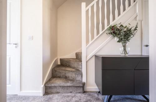 a staircase in a home with a vase of flowers at Beautiful Home in Kingston-Upon-Hull in Hull