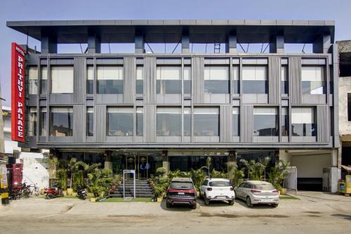 two cars parked in a parking lot in front of a building at Hotel The Prithvi, Near Delhi Airport in New Delhi